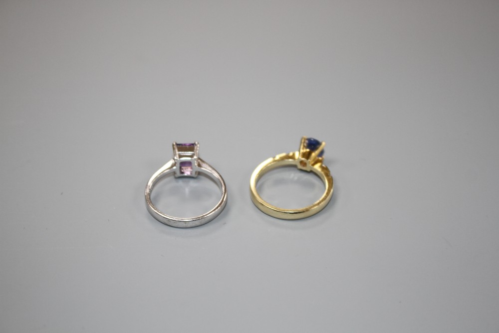 A yellow metal and single stone oval cut Ceylon? sapphire ring with diamond set shoulders and a 750 amethyst ring.